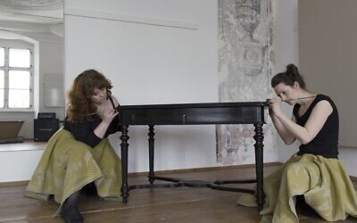 Helen Emily Davy, left, and Katharina Mayrhofer pose with the table taken from the Wertheimer family during the Holocaust. (Courtesy)