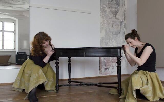 Helen Emily Davy, left, and Katharina Mayrhofer pose with the table taken from the Wertheimer family during the Holocaust. (Courtesy)