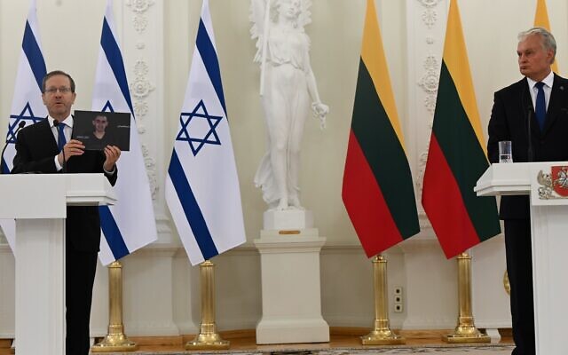 President Isaac Herzog holds up a photo of hostage Rom Braslavski as he speaks alongside Lithuanian President Gitanas Nausėda, in Vilnius, on August 4, 2025. (Omer Meron/GPO) President Isaac Herzog holds up a photo of hostage Rom Braslavski as he speaks alongside Lithuanian President Gitanas Nausėda, in Vilnius, on August 4, 2025. (Omer Meron/GPO)