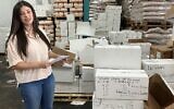 Najwa Mulla, a volunteer, stands in a warehouse in the Druze village of Julis, Galilee, next to boxes of medical supplies that will be sent to hospitals in Sweida, Syria, on August 6, 2025. (Diana Bletter/Times of Israel)