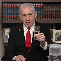 Prime Minister Benjamin Netanyahu holds a glass of water in a video address to the Iranian people, on August 12, 2025. (Government Press Office)