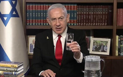 Prime Minister Benjamin Netanyahu holds a glass of water in a video address to the Iranian people, on August 12, 2025. (Government Press Office)