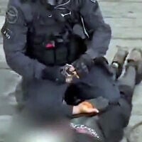 A police officer handcuffs a West Bank resident during his arrest on suspicion of planning an attack in Ra'anana, August 13, 2025. (Screenshot/Israel Police)