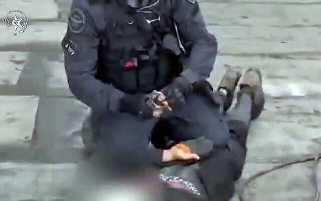 A police officer handcuffs a West Bank resident during his arrest on suspicion of planning an attack in Ra'anana, August 13, 2025. (Screenshot/Israel Police)
