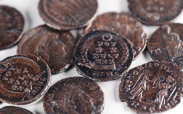 A hoard of bronze coins from the time of the Gallus Revolt (351-352 CE), the third Jewish revolt against the Romans, was discovered in a hiding complex lying beneath the ancient settlement of Huqoq in the Lower Galilee, in a discovery announced on September 18, 2025. (Emil Aladjem/Israel Antiquities Authority)