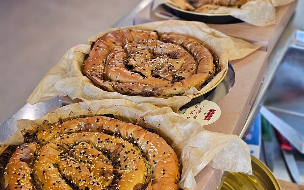 A row of Lalush spanikopita pies created in Tel Aviv's Lechamim bakery after October 7, 2023 (Courtesy)