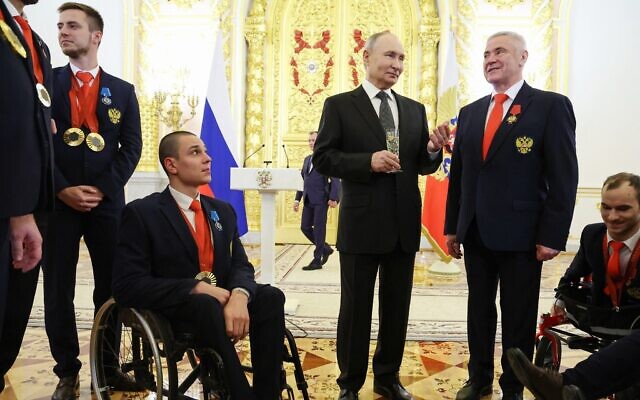 In this pool photograph distributed by the Russian state agency Sputnik, Russia's President Vladimir Putin stands with a glass among Russian Paralympians, medallists from the Paris 2024 Paralympic Games following a state awards ceremony at the Kremlin in Moscow on December 16, 2024. (Alexander KAZAKOV / POOL / AFP) In this pool photograph distributed by the Russian state agency Sputnik, Russia's President Vladimir Putin stands with a glass among Russian Paralympians, medallists from the Paris 2024 Paralympic Games following a state awards ceremony at the Kremlin in Moscow on December 16, 2024. (Alexander KAZAKOV / POOL / AFP)
