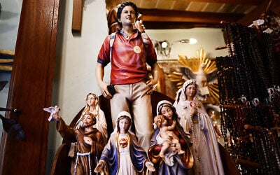 Figurines of Carlo Acutis on sale in a souvenir shop in Assisi, where Acutis's body is on display, April 3, 2025. (Photo by Tiziana FABI / AFP)