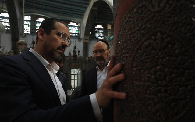 Henry Hamra (left) looks at the Torah scroll at the Ifrange Synagogue in the Jewish Quarter in Old Damascus on April 29, 2025. (Bakr ALKASEM / AFP)
