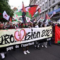 FILE: Anti-Israel protesters and BDS activists hold Palestinian flags and a banner reading 'Country of apartheid ... Israel,' during a demonstration prior to the grand final of the Eurovision Song Contest 2025 in Basel, Switzerland, May 17, 2025. (SEBASTIEN BOZON / AFP)
