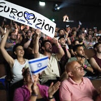 People cheer as they watch the 2025 Eurovision Song Contest finals being screened at a community center in Tel Aviv, Israel, on May 17, 2025. (Maya Levin / AFP)