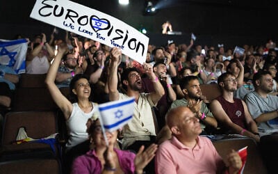 People cheer as they watch the 2025 Eurovision Song Contest finals being screened at a community center in Tel Aviv, May 17, 2025. (Maya Levin / AFP)