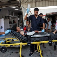 A Palestinian boy, who was injured by gunfire while waiting for aid trucks entering the northern Gaza Strip through Zikim crossing, is unloaded off an ambulance after arriving for medical care at the Shifa Hospital in Gaza City, July 27, 2025. (Omar Al-Qattaa/AFP)