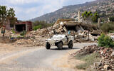 An armoured vehicle of the United Nations Interim Force in Lebanon (UNIFIL) moves past destroyed buildings along a road in the village of Kfar Kila in southern Lebanon near the border with northern Israel on August 27, 2025. (ANWAR AMRO / AFP)