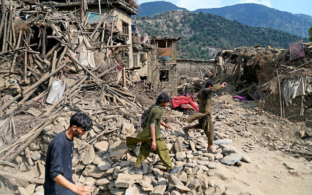 Afghans walk past damaged houses, after earthquakes at Mazar Dara village in Nurgal district, Kunar province, in Eastern Afghanistan, on September 1, 2025 (Wakil Kohsar / AFP)