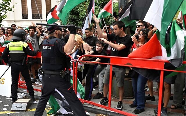 Basque regional police 'Ertzaintza' officer lifts a truncheon as pro-Palestinian, anti-Israel protesters holding Palestinian flags demonstrate during the eleventh stage of the Vuelta a Espana cycling tour, a 167 km race from Bilbao to Bilbao, on September 3, 2025. (Photo by ANDER GILLENEA / AFP) Basque regional police 'Ertzaintza' officer lifts a truncheon as pro-Palestinian, anti-Israel protesters holding Palestinian flags demonstrate during the eleventh stage of the Vuelta a Espana cycling tour, a 167 km race from Bilbao to Bilbao, on September 3, 2025. (Photo by ANDER GILLENEA / AFP)