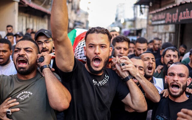 Mourners chant slogans as they carry the body of Mohammad al-Madani, who was killed earlier in the day during an Israeli army raid on the Balata camp for Palestinian refugees, east of Nablus in the West Bank on September 3, 2025. (Zain JAAFAR / AFP)