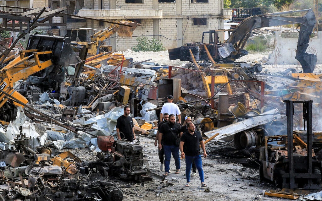 People inspect damaged bulldozers, excavators, and other vehicles in the aftermath of overnight Israeli airstrikes said to be targeting Hezbollah, on an industrial complex servicing heavy construction machinery in the coastal town of Ansariyah in southern Lebanon on September 4, 2025 (MAHMOUD ZAYYAT / AFP)