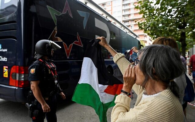 A Pro-Palestinian, anti-Israel protester shouts at Team Israel Premier-Tech's bus at the start of the 12th stage of the Vuelta a Espana on September 4, 2025. (Photo by ANDER GILLENEA / AFP)