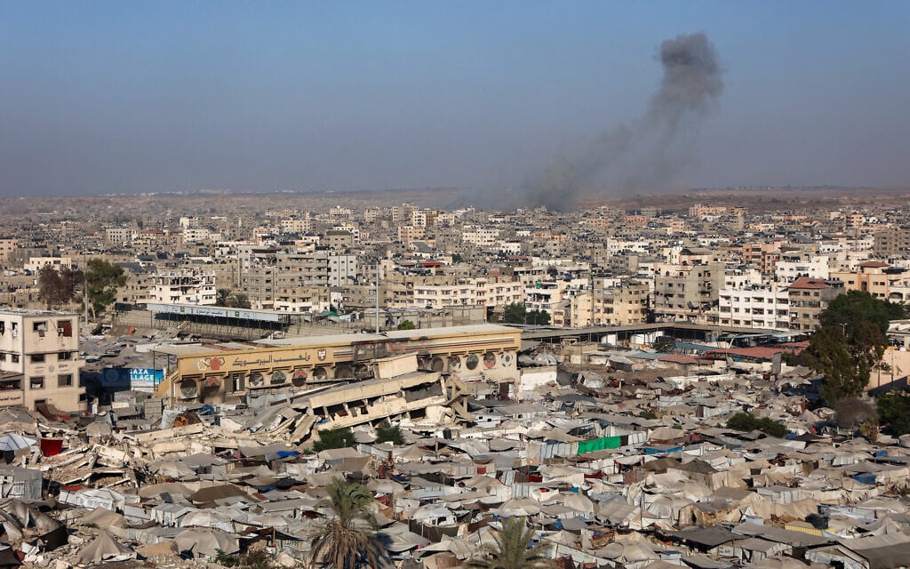 A picture shows a view of a makeshift displacement camp at the Yarmuk Sports Stadium, once a football arena, as smoke billows during Israeli strikes on Gaza City on September 4, 2025. (Omar AL-QATTAA / AFP)