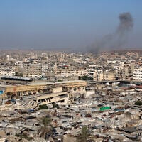 A picture shows a view of a makeshift displacement camp at the Yarmuk Sports Stadium, once a football arena, as smoke billows during Israeli strikes on Gaza City on September 4, 2025. (Omar AL-QATTAA / AFP)