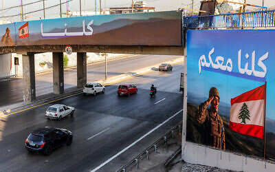 Motorists drive past billboards depicting a Lebanese army soldier saluting the national flag with the Arabic slogan "We are all with you" along the highway leading to Beirut International Airport in southern Beirut on September 5, 2025. (ANWAR AMRO / AFP) Motorists drive past billboards depicting a Lebanese army soldier saluting the national flag with the Arabic slogan "We are all with you" along the highway leading to Beirut International Airport in southern Beirut on September 5, 2025. (ANWAR AMRO / AFP)