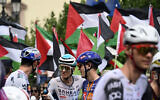Pro-Palestinian, anti-Israel protesters wave flags as riders await the start of the 15th stage of the Vuelta a Espana cycling tour, a 167 km race between A Veiga/Vegadeo and Monforte de Lemos, on September 7, 2025. (Miguel RIOPA / AFP)