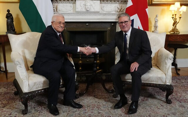 Britain's Prime Minister Keir Starmer (R) shakes hands with Palestinian Authority President Mahmoud Abbas at the beginning of their meeting at 10 Downing Street in London on September 8, 2025. (Photo by Jonathan Brady / POOL / AFP)