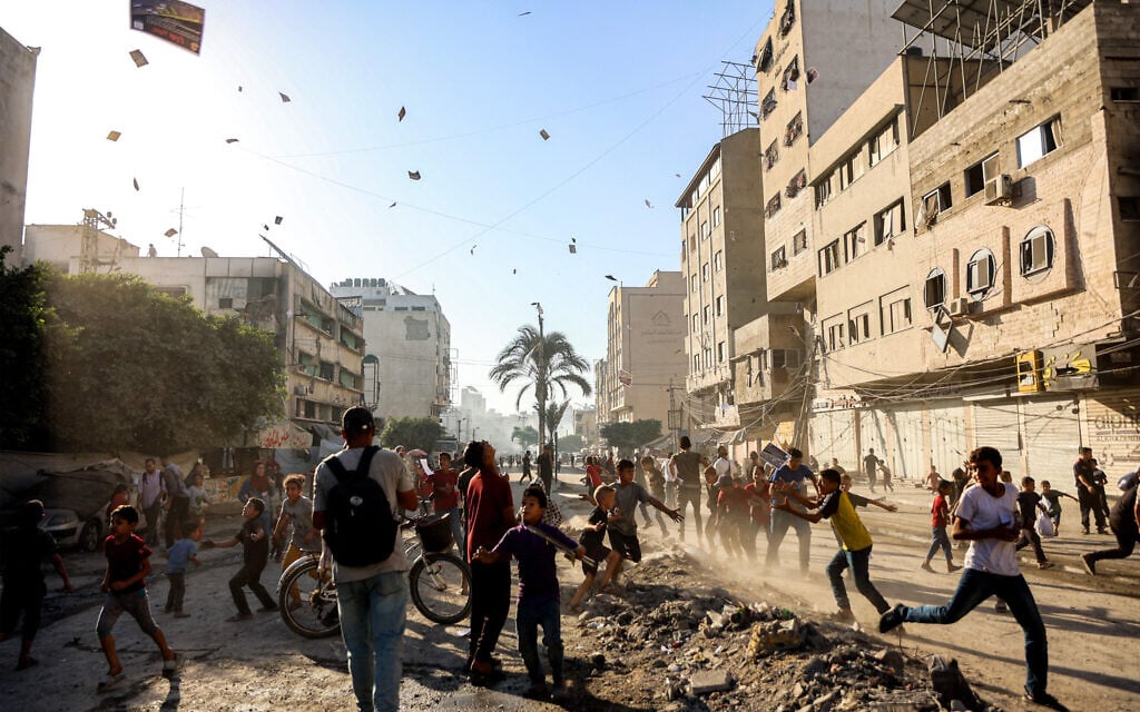 People watch as leaflets dropped by the Israeli military urging evacuation south to al-Mawasi land in Gaza City on September 9, 2025. (Omar AL-QATTAA / AFP)