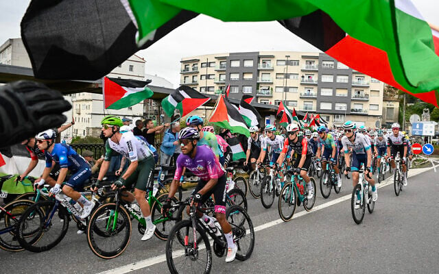 Anti-Israel, pro-Palestinian protesters wave flags and shout as the peloton rides by in Poio at the start of the 16th stage of the Vuelta a Espana on September 9, 2025. (Photo by Miguel RIOPA / AFP) Anti-Israel, pro-Palestinian protesters wave flags and shout as the peloton rides by in Poio at the start of the 16th stage of the Vuelta a Espana on September 9, 2025. (Photo by Miguel RIOPA / AFP)