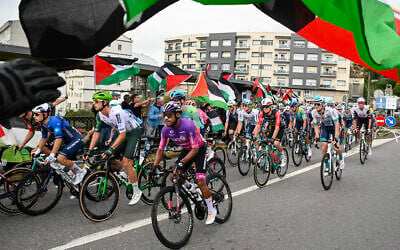 Pro-Palestinian, anti-Israel protesters wave flags and shout as the peloton rides by in Poio at the start of the 16th stage of the Vuelta a Espana on September 9, 2025. (Miguel Riopa/AFP)
