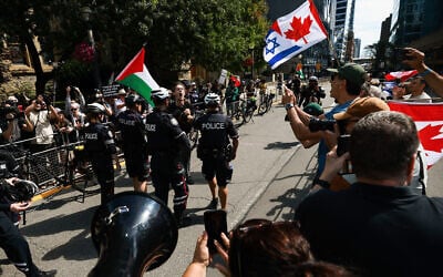 A protester is detained by police after jumping a barricade as demonstrators rally on opposite sides of the street in front of the Roy Thomson Hall, where the documentary 'The Road Between Us: The Ultimate Rescue' premiered during the Toronto International Film Festival in Toronto, Canada, on September 10, 2025. (Photo by Cole BURSTON / AFP) A protester is detained by police after jumping a barricade as demonstrators rally on opposite sides of the street in front of the Roy Thomson Hall, where the documentary 'The Road Between Us: The Ultimate Rescue' premiered during the Toronto International Film Festival in Toronto, Canada, on September 10, 2025. (Photo by Cole BURSTON / AFP)