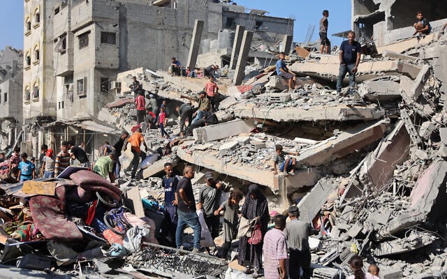 Palestinians check a destroyed building following an overnight strike on al-Shati neighborhood, west of Gaza City, on September 12, 2025. (Omar AL-QATTAA / AFP)