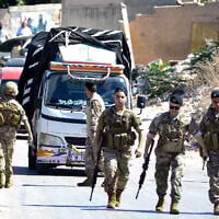 Lebanese army soldiers stand guard as a truck loaded with weapons leaves the Palestinian refugee camp of Beddawi, near the northern city of Tripoli on September 13, 2025 (Fathi Al-Masri / AFP)