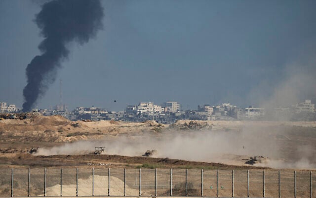 Army tanks move inside the Gaza Strip as smoke billows in the background, on September 22, 2025. (Maya Levin / AFP)