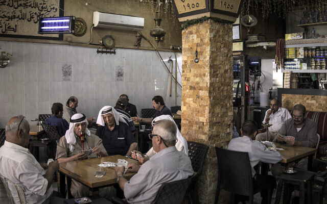 Palestinian men play cards together at a coffee shop in the West Bank city of Ramallah on September 22, 2025. (John Wessels/AFP) Palestinian men play cards together at a coffee shop in the West Bank city of Ramallah on September 22, 2025. (John Wessels/AFP)