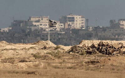 An Israeli flag flutters near destroyed buildings inside the Gaza Strip as pictured from the Israeli border, on September 25, 2025. (Jack GUEZ / AFP)
