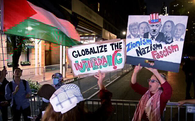 Anti-Israel activists hold signs calling to "globalize the intifada" and comparin Zionism to Nazism during the "Autonomous Noise Demonstration for Gaza" outside the hotel of Prime Minister Benjamin Netanyahu in New York City on September 25, 2025. (Leonardo Munoz/AFP)