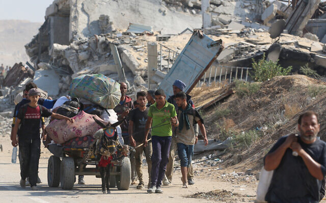 Palestinians transport humanitarian aid they received at a distribution center run by the US and Israeli-backed Gaza Humanitarian Foundation (GHF), at the so-called "Netzarim corridor", in Nuseirat in the central Gaza Strip, on September 26, 2025. (Photo by Eyad BABA / AFP)