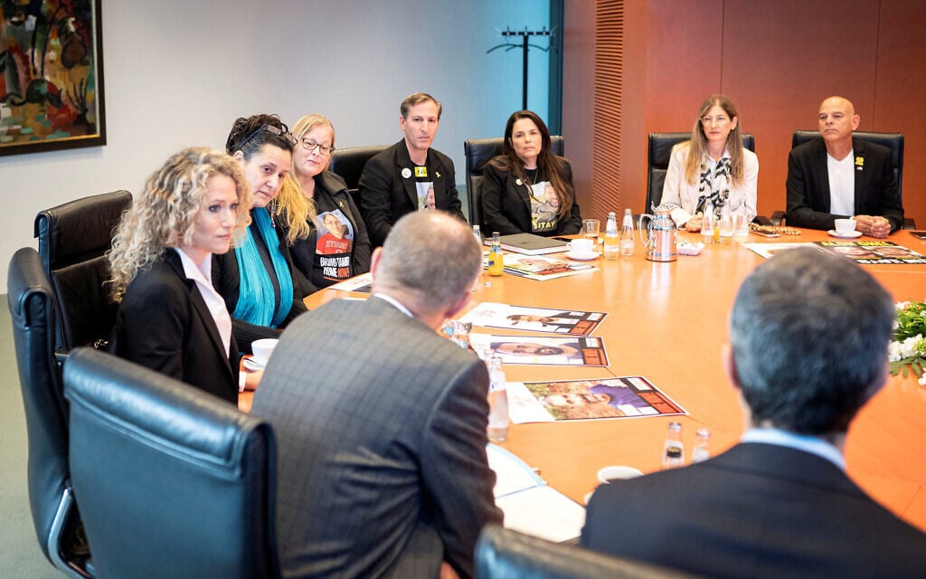 This handout photo taken and released by the press office of the German government shows German Chancellor Friedrich Merz (front second right) speaking with relatives of hostages held in Gaza during a meeting at the Chancellery in Berlin on September 30, 2025. (Guido BERGMANN / BUNDESREGIERUNG / AFP)