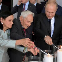 Russian President Vladimir Putin, right, and Aron Bell, center, light candles at an unveiling ceremony of a monument to the Heroes of Resistance at Nazi concentration camps and Jewish ghettos during the World War II, at the Jewish Museum and Tolerance Center in Moscow, Russia, June 4, 2019. (Alexei Druzhinin, Sputnik, Kremlin Pool Photo via AP)