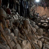 In this July 17, 2019 photo, young Palestinians sit among ancient artifacts displayed inside Shahwan private museum in a basement of a building in town of Khan Younis, Southern Gaza Strip. (AP Photo/Khalil Hamra)
