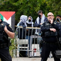 Security officers stand outside a barricade as pro-Palestinian, anti-Israel protesters gather on the campus of the University of California, Los Angeles, May 23, 2024. (AP Photo/Damian Dovarganes)
