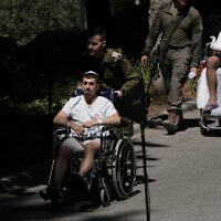 Wounded IDF soldiers arrive for the funeral of a comrade at Mt. Herzl Military Cemetery in Jerusalem, July 8, 2025. (AP Photo/Maya Alleruzzo)