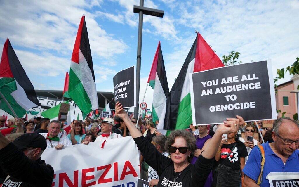 A demonstrator holds a placard that reads 'You are all an audience to genocide' during a march in support of the Palestinian people in Gaza, during the Film Festival in Venice, Italy, August 30, 2025. (Photo by Alessandra Tarantino/Invision/AP) A demonstrator holds a placard that reads 'You are all an audience to genocide' during a march in support of the Palestinian people in Gaza, during the Film Festival in Venice, Italy, August 30, 2025. (Photo by Alessandra Tarantino/Invision/AP)