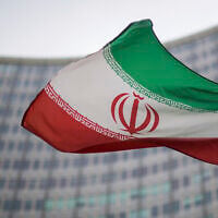 A national flag of Iran waves in front of the building of the International Atomic Energy Agency, IAEA, in Vienna, Austria, December 17, 2021. (AP Photo/Michael Gruber, File)