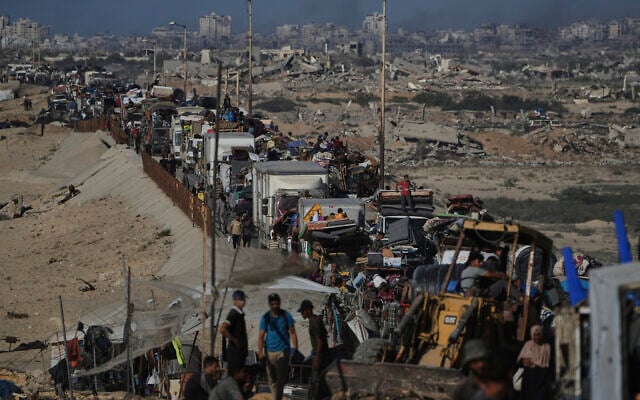 Displaced Palestinians fleeing northern Gaza carry their belongings along the coastal road toward southern Gaza, September 10, 2025. (AP Photo/Abdel Kareem Hana)