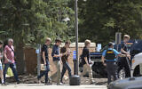 Students walk to board a bus amid heavy police presence at the Evergreen Library after a shooting at Evergreen High School in Evergreen, Colorado, September 10, 2025. (Hyoung Chang/The Denver Post via AP)