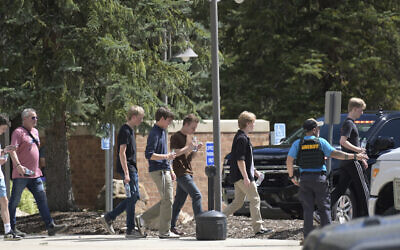 Students walk to board a bus amid heavy police presence at the Evergreen Library after a shooting at Evergreen High School in Evergreen, Colorado, September 10, 2025. (Hyoung Chang/The Denver Post via AP)