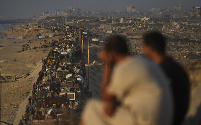 Palestinians flee northern Gaza by foot and in vehicles, carrying their belongings along the coastal road toward southern Gaza, on September 15, 2025. (AP/Abdel Kareem Hana)